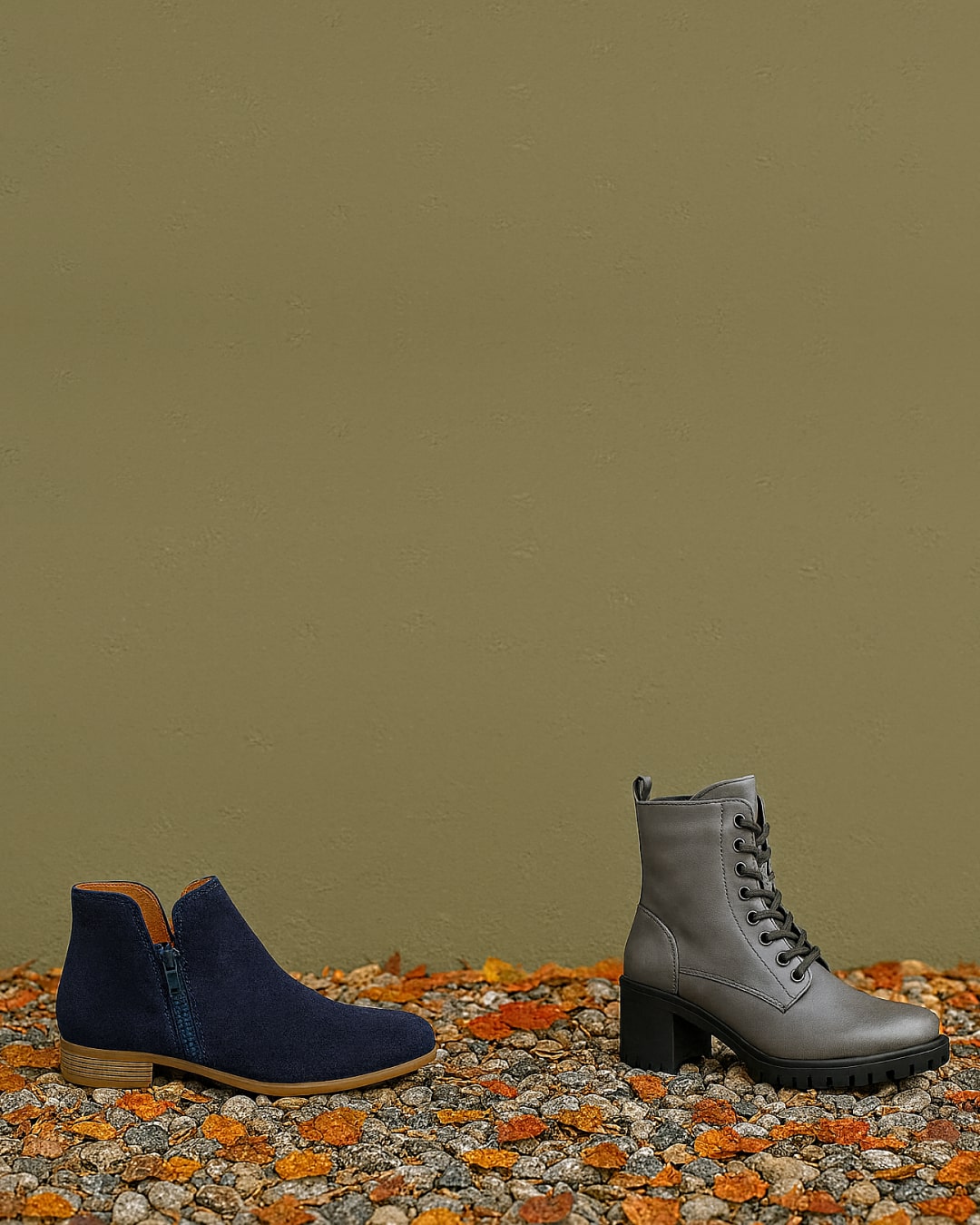Pair of navy blue and gray boots on a textured surface with a green background